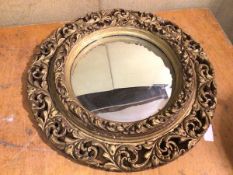 A Shona Aisonea circular wall mirror with convex glass within a gilt pierced frame (d.59cm)
