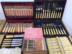 A collection of cutlery including two canteens with knives and forks, and three other boxes, one