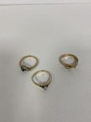 A group of three 9ct gold rings one with pearl flanked by three blue stones another with blue