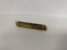 A coloured Aventurine (gold stone) bar brooch in green and gold mounted in unmarked yellow metal