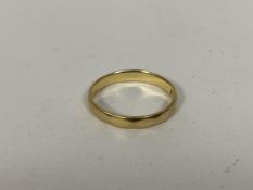 An 18ct gold wedding band size M and weighs 2.61 grammes