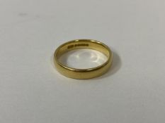 An 18ct gold wedding band, size R, weighs 4.83 grammes