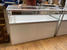 A modern display jewellery counter with glass to top and sides, light to corner above storage