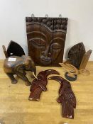 A quantity of carvings including a south east Asian sectional wall panel depicting woman's face,