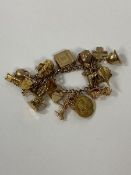 A 9ct gold charm bracelet with a quantity of charms, most marked 9ct, measures 8cm, combined