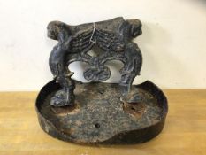 A 19thc cast iron boot scrape and tray, scrape in the form of two winged beasts, measures 26cm