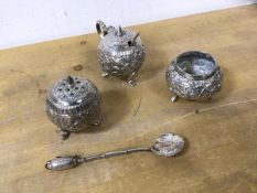A collection of Indian white metal including condiment pot, pepper pot, and spoon with leaf style