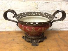 A china and brass mounted two handled jardiniere with pierced border raised on a pierced and