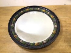 A late 19th early 20thc wall mirror, the bevelled circular glass within an ebonised frame with inner