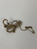 A floral spray style brooch marked 375, also marked with an omega, with diamonds and pink stones, (