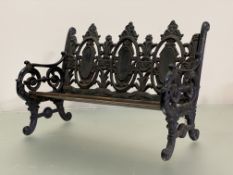 A miniature cast iron bench after a Coalbrookdale design, with slatted wooden seat. 27.5cm by 41cm
