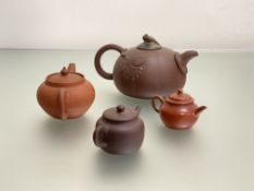 A Chinese Yixing red stoneware teapot modelled as a pumpkin with leaves in relief and with carved