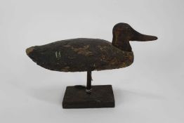 Wooden decoy duck raised on stand