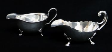 TWO GEORGE V SILVER SAUCE BOATS, one with cut card edge and flying scroll handle on hoof feet by