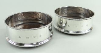 PAIR OF ELIZABETH II SILVER BOTTLE COASTERS, maker J M & S, London 1987, having turned wooden bases,