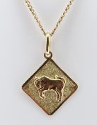 YELLOW METAL BULL PENDANT, indistinctly hallmarked, on 10k gold chain measuring 64cms, 12.6gms
