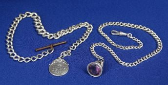 TWO SILVER ALBERTS, one having a base metal T-bar and silver fob depicting a golfing scene, 38cms