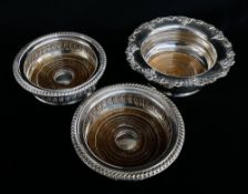THREE ELECTROPLATED WINE COASTERS, the pair with gadrooned rims, 14.5cms diam, the single with
