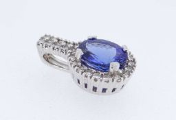 WHITE METAL TANZANITE & DIAMOND PENDANT, the oval tanzanite (11 x 10mms) surrounded by twenty-