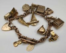 9CT GOLD CHARM BRACELET, having trombone links, heart shaped padlock, having various mainly 9ct gold