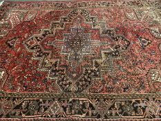 RED GROUND IRANIAN RUG with central multiple diamond pattern and label 'Iran Heriz Gerouan', 226 x