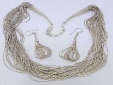 A STERLING SILVER NECKLACE - of fine multi 'strings' with tiny yellow metal ball links together with