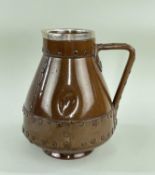 DOULTON LAMBETH SILICON WARE JUG, in the form of a copper finish riveted jack, silver rim, London