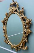 ROCOCO-STYLE GILTWOOD MIRROR, of oval form with elaborate scrolling giltwood border (damaged