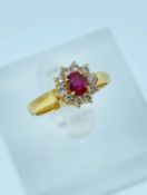 YELLOW METAL BELIEVED RUBY & DIAMOND CLUSTER RING, the centralstone surrounded by ten diamonds, ring