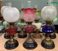 SEVEN ASSORTED VICTORIAN/EDWARDIAN OIL LAMPS, all converted to electricity, with associated coloured