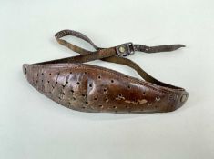 SHETLAND LEATHER MAKKIN BELT, pierced and stuffed oval pad, overall 80cms incl strap Provenance: '