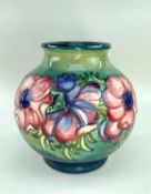 PRE-WAR MOORCROFT ANEMONE PATTERN GLOBULAR VASE with tube lined decoration on green ground,
