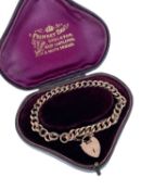 9CT GOLD CURB LINK BRACELET, having heart shaped padlock, 12.1gms, in fitted Prinsky Bros