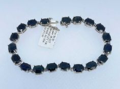 10K WHITE GOLD SAPPHIRE BRACELET, set with nineteen oval cut sapphires, 20cms long, 12.9gms