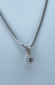 18K DIAMOND PENDANT on white gold box link chain stamped '750', the single diamond measuring 0.25cts