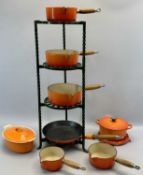 LE CREUSET ORANGE ENAMELLED CAST IRON PANS (7), and a green wrought metal four tier pan stand