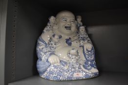 A large porcelain figure of a seated Buddha