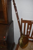 A traditional copper and brass warming pan