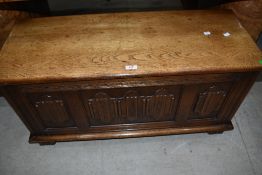 A mid C20th oak jacobean style blanket box having applique linen fold decoaration