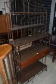 A modern wrought iron frame shelf/display having tiered top, shelf and drawers