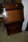 An early C20th oak bookcase bureau having fall front over shelves, w 60cm