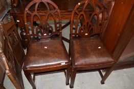 A pair of period style oak dining chairs, having Gothic arch backs with chamfered legs