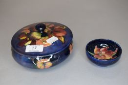 Two pieces of vintage Moorcroft, a lidded pot having blue ground with orchid design(AF) and a
