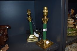 A pair of vintage brass columned table lamps having painted green stems.