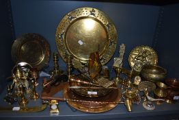 A large collection of brass and copper wares including candle snuffer, chargers, miniatures and