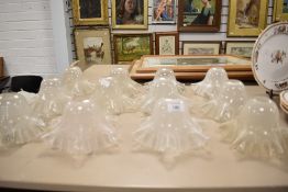 Twelve vintage fluted glass shades having ribbed edges.