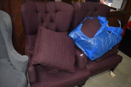 A pair of modern button back armchairs in burgundy upholstery, with additional cushions