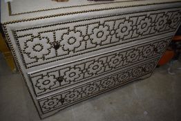 An upholstered and stud style decorated chest of drawers