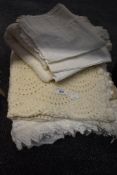 A collection of vintage throws including knitted examples, Broderie Anglais nightdress cases and