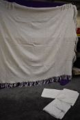A vintage patterned waffle bed throw in white and a selection of vintage sheets.
